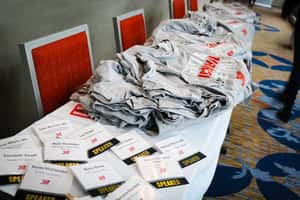 A table with gray Jett t-shirts and flyers on it
