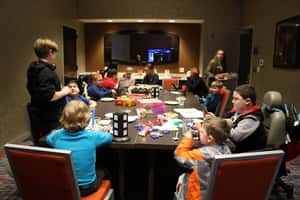 A group of children sitting around a large table with games in front of them
