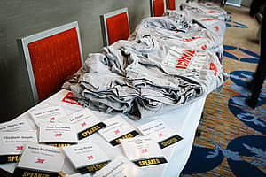 A table with gray Jett t-shirts and flyers on it
