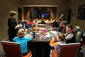 A group of children sitting around a large table with games in front of them