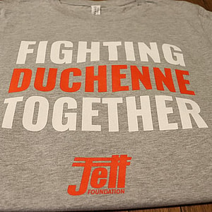 solid gray t-shirt with fighting duchenne together text, fighting written in white, duchenne written in red, together written in white, with the jett logo written underneath in red