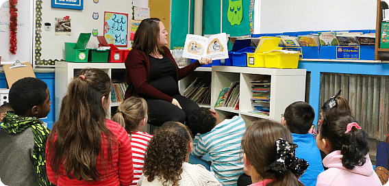 woman reading a children's book to children