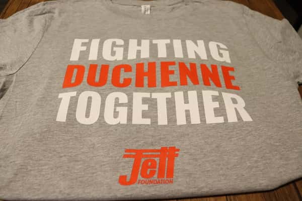 solid gray t-shirt with fighting duchenne together text, fighting written in white, duchenne written in red, together written in white, with the jett logo written underneath in red