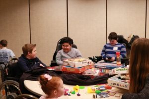 A group of children sitting around a table with board games in front of them