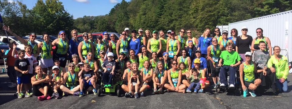 large group of triathlon runners posing together