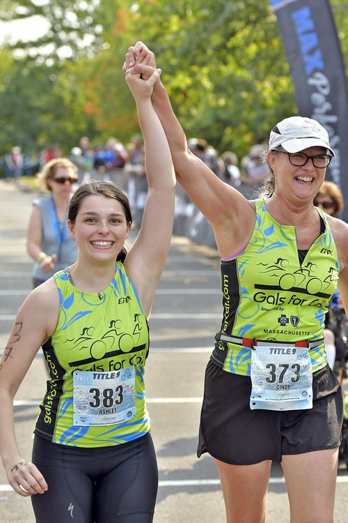 two triathlon runners raising hands together