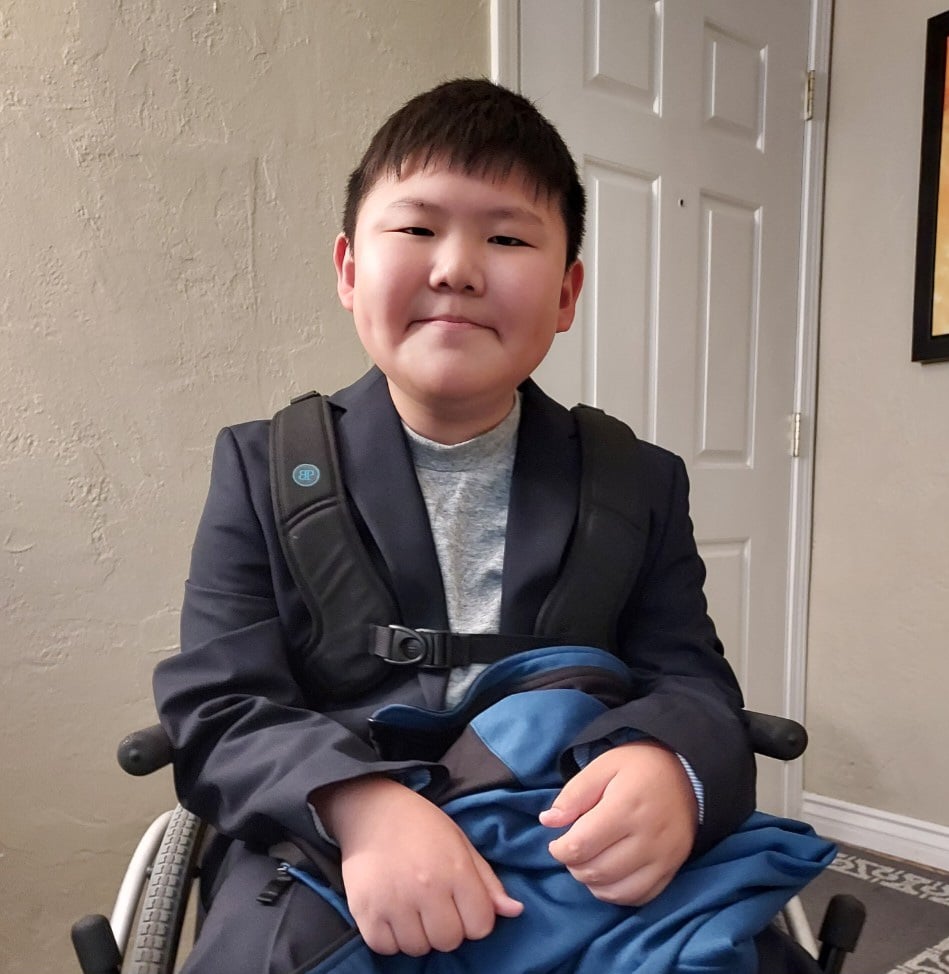 AVF recipient Timothy sits smiling in his wheelchair